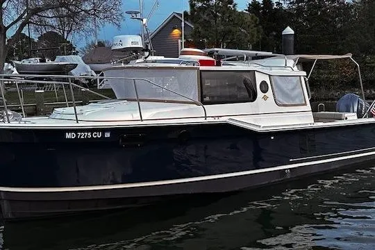 Slide: The Image of 2024 Ranger Tugs R-27 docked at sunset, serene waterfront setting. - 2