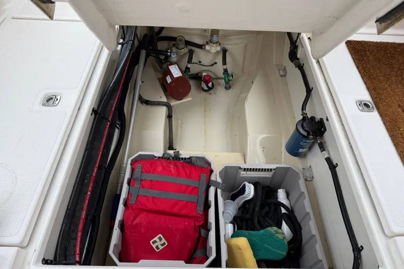 Slide: The Image of 2024 Ranger Tugs R-27 engine compartment with water heater and black tank. - 29