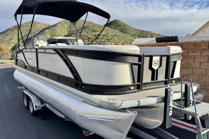 Slide: The Image of 2020 Godfrey Monacco 255 SD pontoon boat on trailer, scenic mountain backdrop. - 1