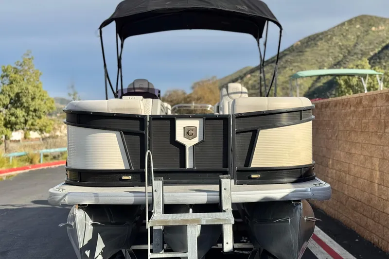 Slide: The Image of 2020 Godfrey Monacco 255 SD pontoon boat with canopy, parked outdoors. - 2