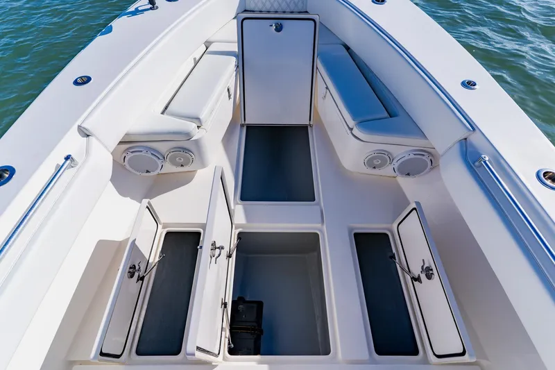 Slide: The Image of 2025 Contender 32 ST boat interior with open storage compartments and cushioned seating. - 18