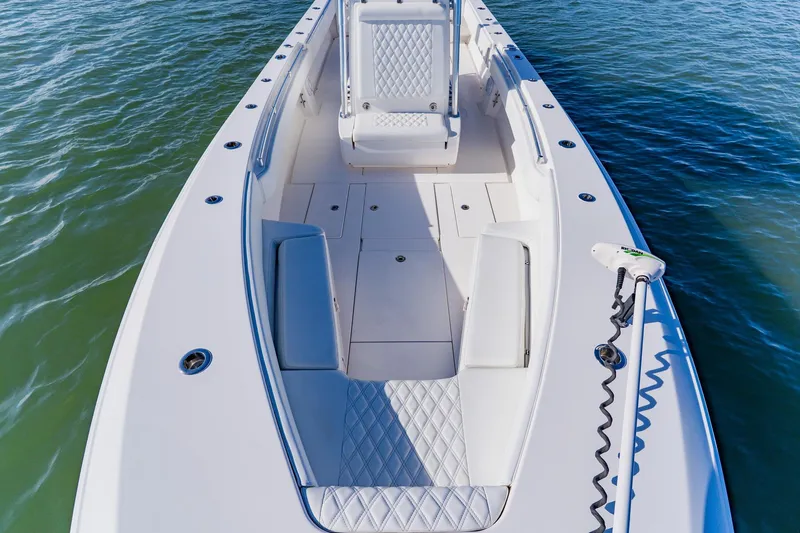 Slide: The Image of 2025 Contender 32 ST boat, spacious deck, white seating, on calm water. - 20