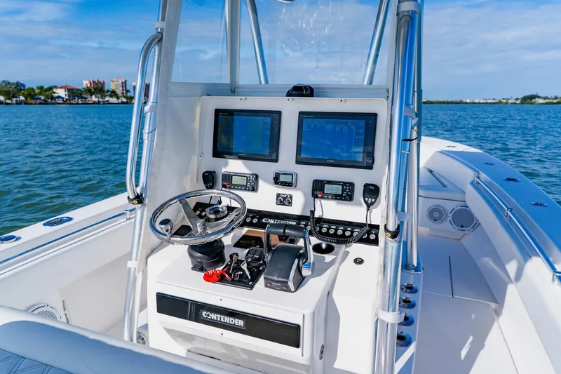 Slide: The Image of 2025 Contender 32 ST boat cockpit with advanced navigation systems and steering wheel on open water. - 25