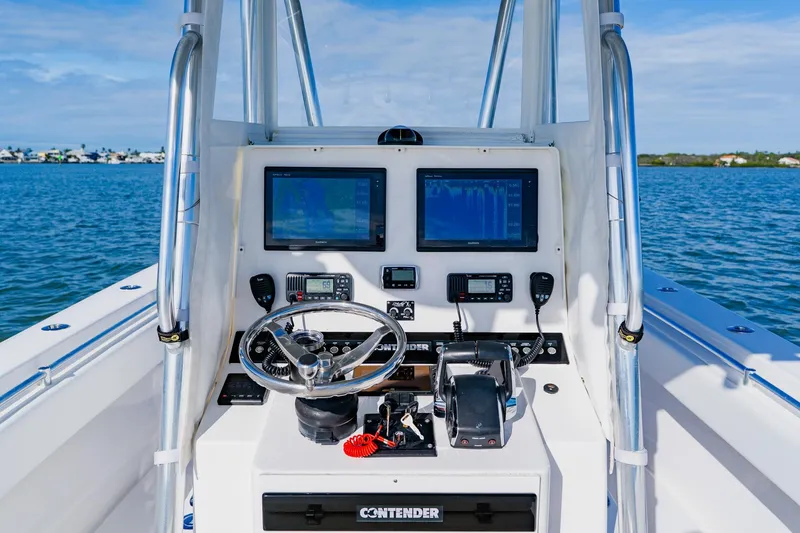 Slide: The Image of 2025 Contender 32 ST boat dashboard with navigation screens and controls on open water. - 29