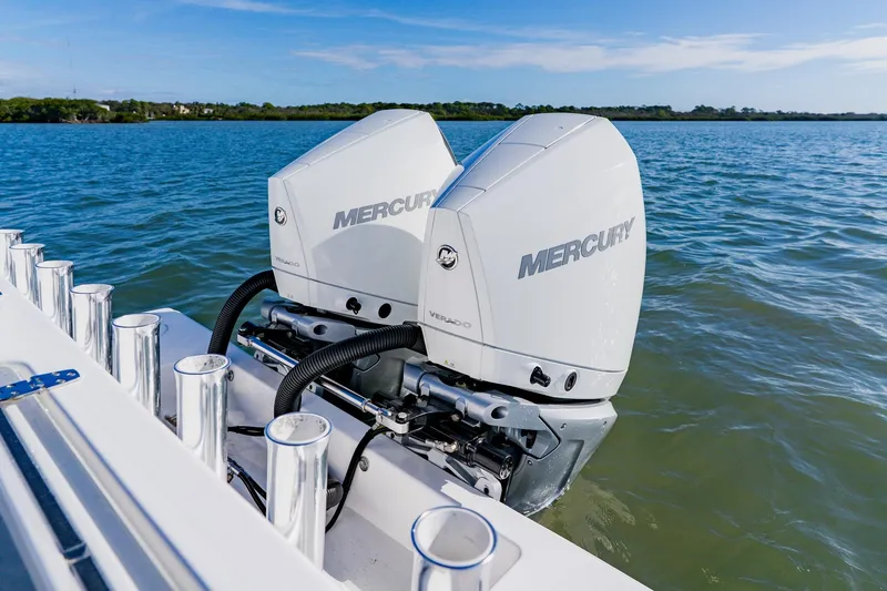 Slide: The Image of 2025 Contender 32 ST boat with dual Mercury outboard engines on a calm lake. - 33