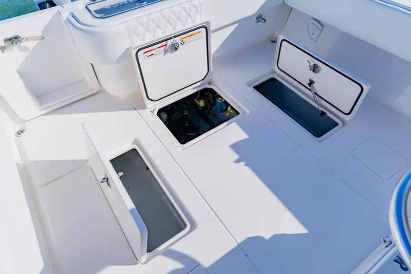 Slide: The Image of 2025 Contender 32 ST boat deck with open storage compartments and clean white finish. - 40
