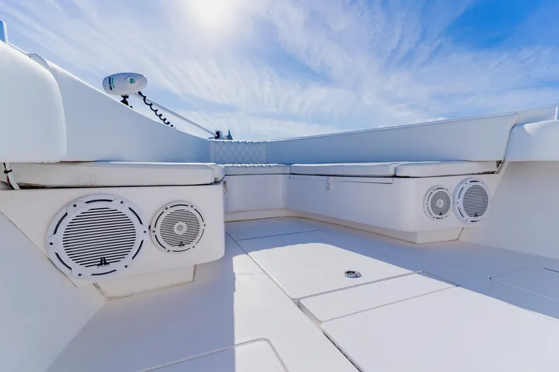Slide: The Image of 2025 Contender 32 ST boat interior with seating and speakers under a clear blue sky. - 43