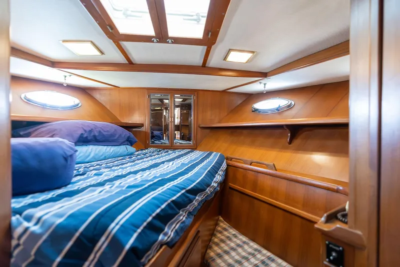 Slide: The Image of 1991 Lien Hwa Cockpit Sundeck cabin with wood paneling and striped bedding. - 21