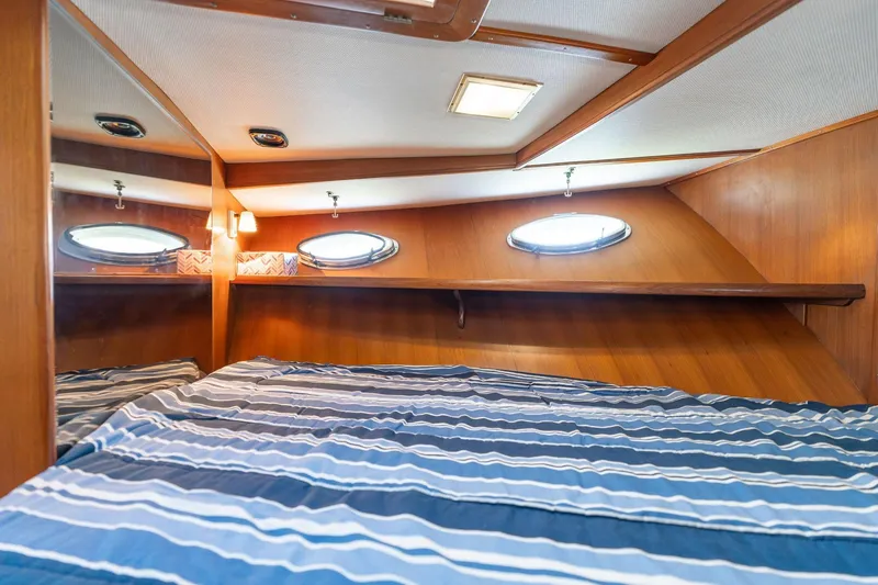 Slide: The Image of 1991 Lien Hwa Cockpit Sundeck interior cabin with striped bedding and porthole windows. - 22