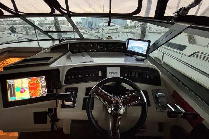 Slide: The Image of 1995 Sea Ray Sundancer 370 helm with navigation screens and steering wheel. - 17