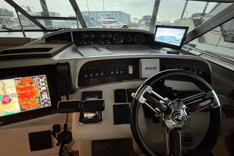 Slide: The Image of 1995 Sea Ray Sundancer 370 helm with navigation screens and steering wheel. - 18