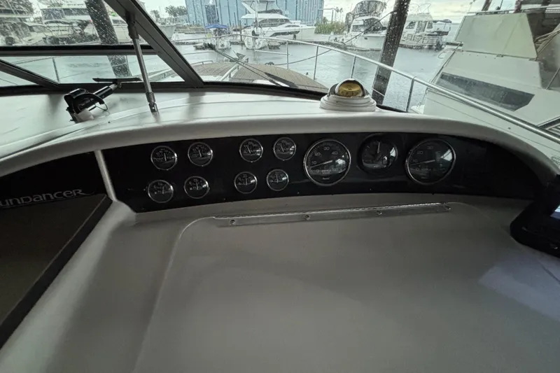Slide: The Image of 1995 Sea Ray Sundancer 370 dashboard with gauges and marina view. - 20