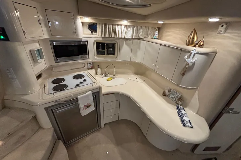 Slide: The Image of 1995 Sea Ray Sundancer 370 yacht kitchen with stove, microwave, and cabinets. - 24