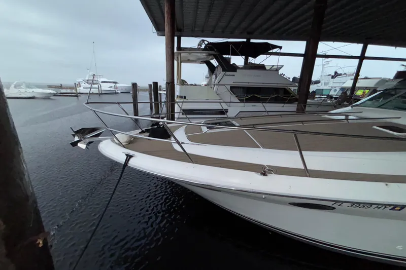 Slide: The Image of 1995 Sea Ray Sundancer 370 docked under a covered marina, surrounded by other boats. - 3
