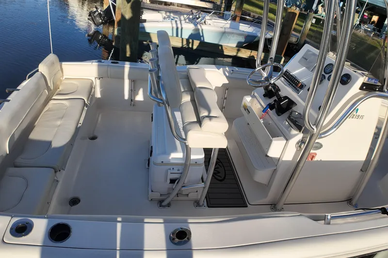 Slide: The Image of 2020 Key West 219 FS boat interior with seating and console, docked by the water. - 11
