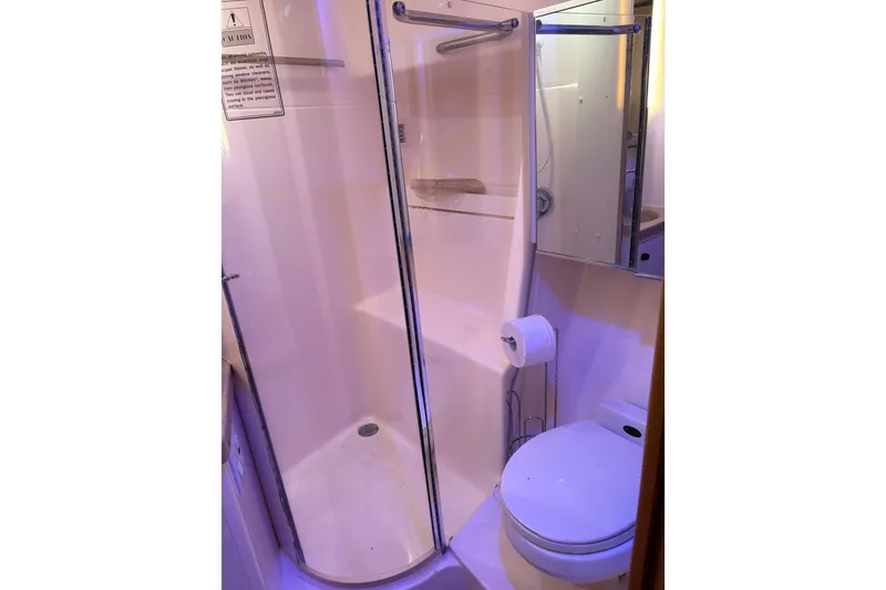 Slide: The Image of 1999 Tiara Yachts 4000 Express cabin with TV, bed, and wooden cabinetry. - 10