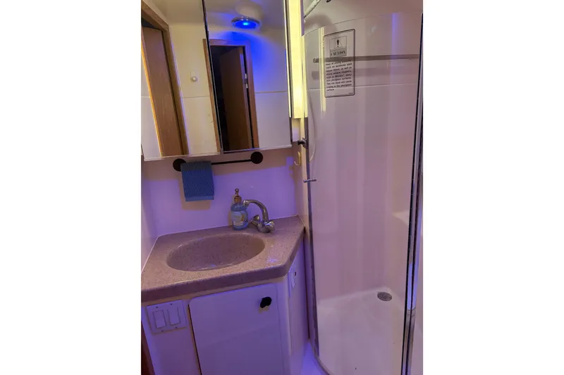Slide: The Image of 1999 Tiara Yachts 4000 Express bathroom with sink, mirror, and shower. - 13