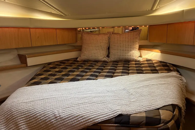 Slide: The Image of 1999 Tiara Yachts 4000 Express cabin with cozy bed and wooden cabinetry. - 15