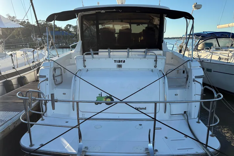 Slide: The Image of 1999 Tiara Yachts 4000 Express docked at marina, rear view with boat details. - 2