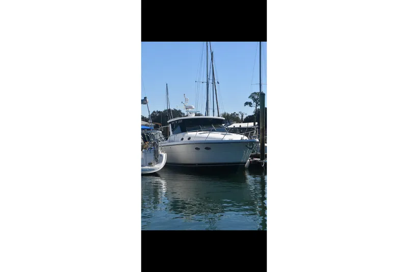 Slide: The Image of 1999 Tiara Yachts 4000 Express cabin with checkered bedding and cozy pillows. - 23