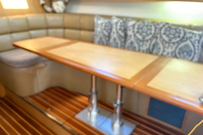 Slide: The Image of Interior of 1999 Tiara Yachts 4000 Express with wooden table and cushioned seating. - 30