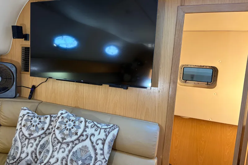 Slide: The Image of Interior of 1999 Tiara Yachts 4000 Express with TV, cushions, and porthole. - 32
