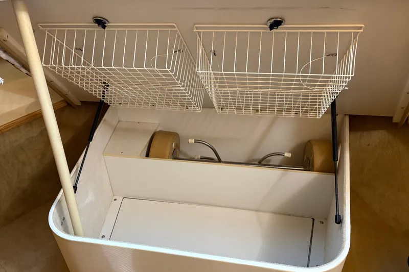 Slide: The Image of Storage compartment in a 1999 Tiara Yachts 4000 Express with wire baskets and hydraulic supports. - 37