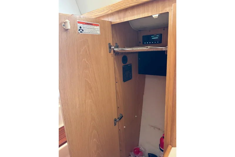 Slide: The Image of 1999 Tiara Yachts 4000 Express interior cabinet with safety equipment and control panel. - 40