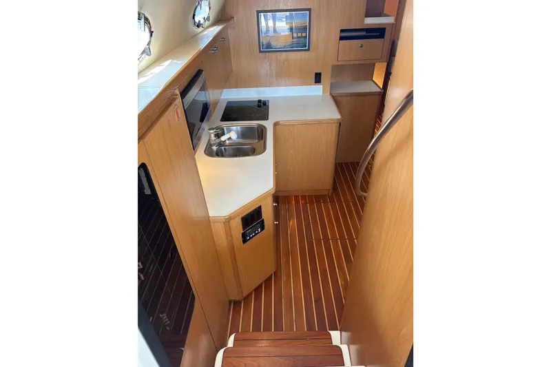 Slide: The Image of 1999 Tiara Yachts 4000 Express interior kitchen with wood cabinetry and flooring. - 41