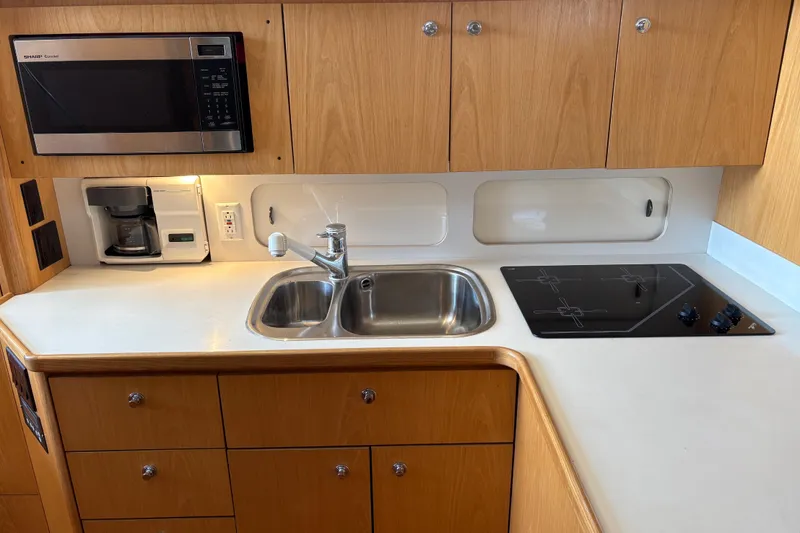 Slide: The Image of 1999 Tiara Yachts 4000 Express kitchen with sink, stove, microwave, and coffee maker. - 42