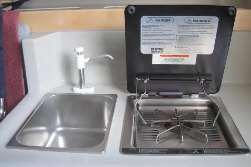 Slide: The Image of Compact kitchen area in a 2022 Corsair 880 Standard, featuring a sink and stove. - 15