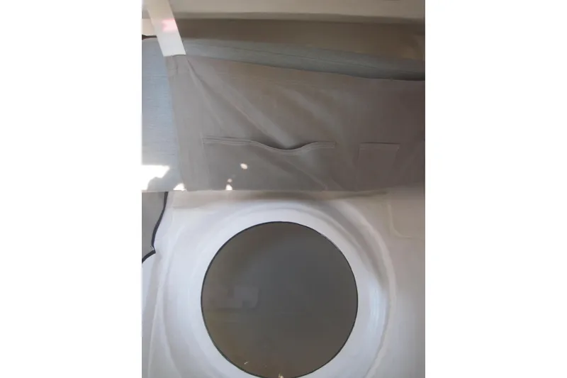 Slide: The Image of Interior view of 2022 Corsair 880 Standard sailboat with storage pocket and circular window. - 18