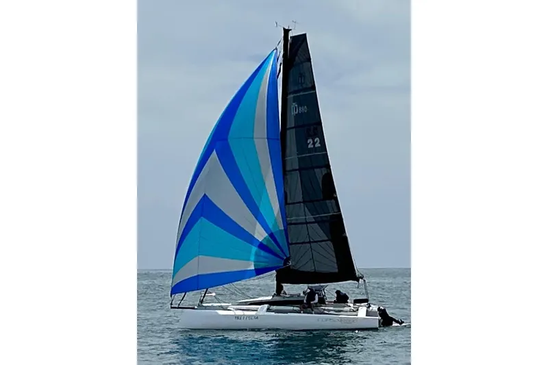 Slide: The Image of Sailboat Corsair 880 Standard 2022 with vibrant blue and white sails on open water. - 2