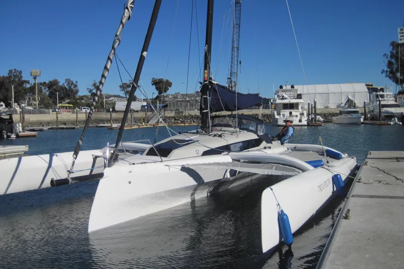 Slide: The Image of 2022 Corsair 880 Standard trimaran docked at a marina under clear blue skies. - 4