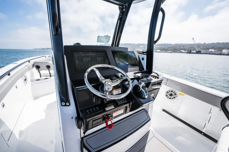 Slide: The Image of 2025 Everglades 285 Center Console boat dashboard with steering wheel and digital displays. - 10