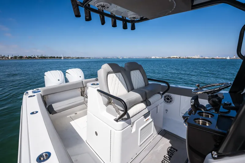 Slide: The Image of 2025 Everglades 285 Center Console boat on calm water, featuring dual engines and modern seating. - 17