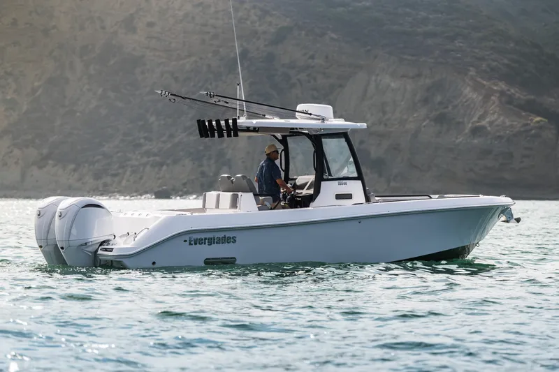 Slide: The Image of 2025 Everglades 285 Center Console boat on water, side view with scenic background. - 5