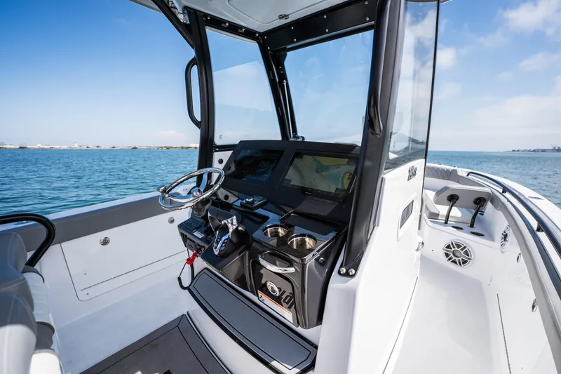 Slide: The Image of 2025 Everglades 285 Center Console boat interior with steering wheel and navigation system. - 8