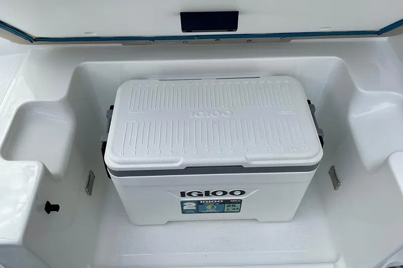 Slide: The Image of White Igloo cooler inside 2026 Tahoe 2150 boat storage compartment. - 12