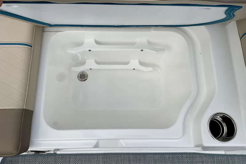 Slide: The Image of Interior view of 2026 Tahoe 2150 boat storage compartment with drain and cup holder. - 14