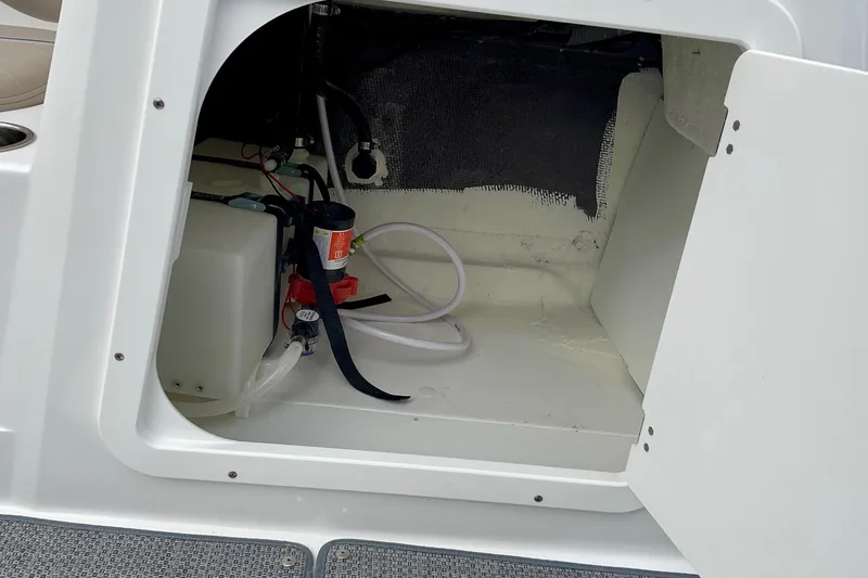Slide: The Image of Open storage compartment in 2026 Tahoe 2150 boat, showing interior equipment and wiring. - 16