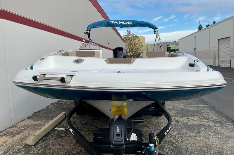 Slide: The Image of 2026 Tahoe 2150 boat on trailer, parked outdoors near industrial buildings. - 18