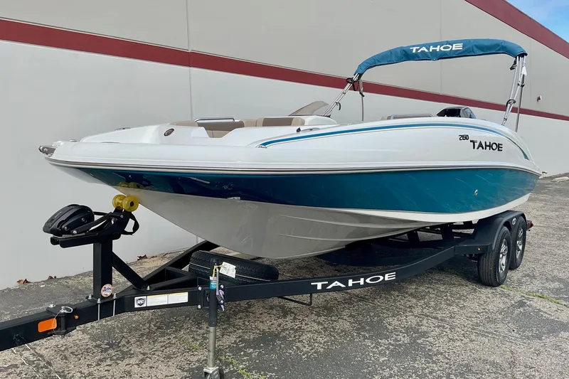 Slide: The Image of 2026 Tahoe 2150 boat on trailer, white and blue design, parked outdoors. - 6