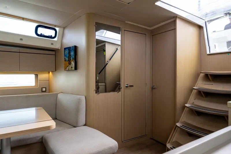 Slide: The Image of Interior of 2020 Beneteau Oceanis 46.1 yacht, featuring modern wood finish and cozy seating area. - 21