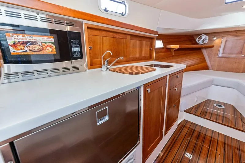 Slide: The Image of Modern MJM 35 yacht interior kitchen with microwave, sink, and wooden cabinetry, 2025 model. - 6