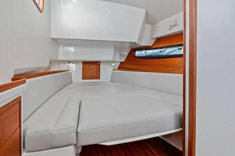 Slide: The Image of 2025 MJM 4 boat interior with sleek white and wood design, featuring a cozy cabin. - 16