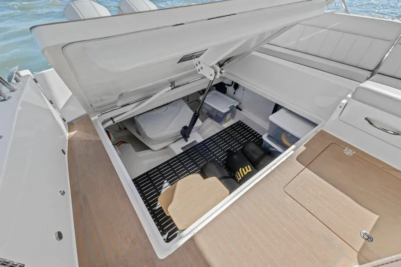 Slide: The Image of Open storage compartment on 2025 MJM 4 boat, showcasing organized interior space. - 26