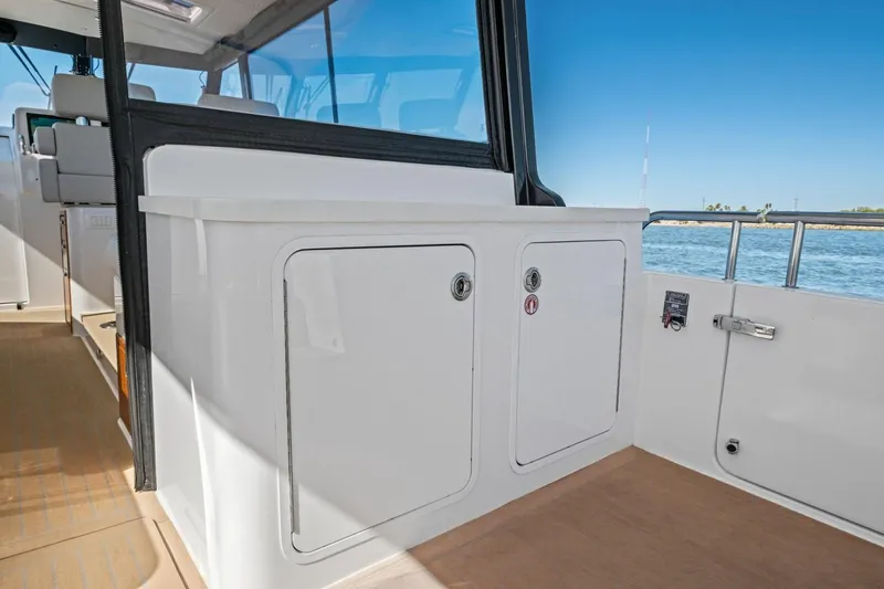 Slide: The Image of Interior view of 2025 MJM 4 boat, featuring sleek cabinetry and ocean backdrop. - 30