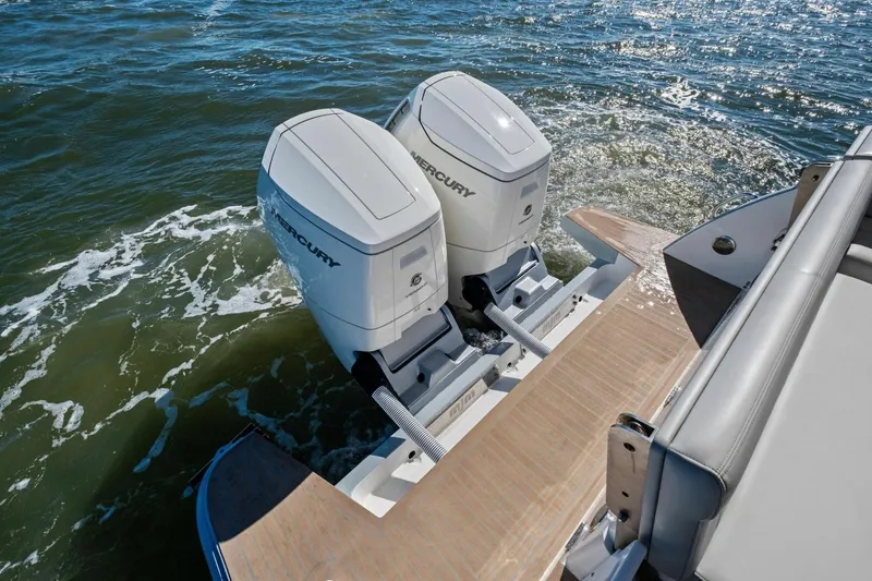 Slide: The Image of Twin Mercury outboard engines on a 2025 MJM 4 boat, cruising through water. - 38