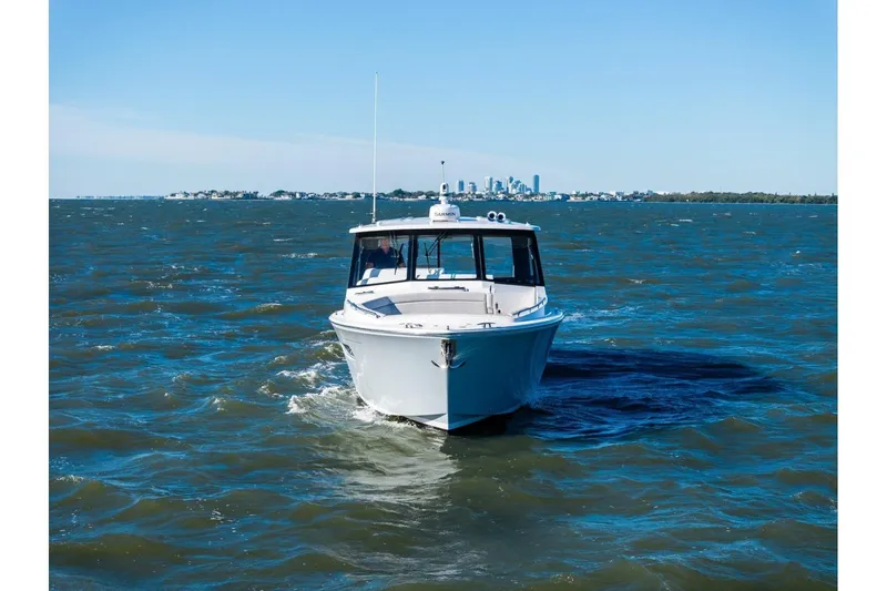 Slide: The Image of 2025 MJM 4 boat cruising on open water with city skyline in background. - 42